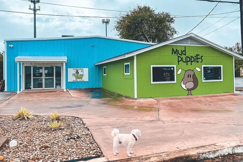 A dog stands outside of the Mud Puppies MoPac Location