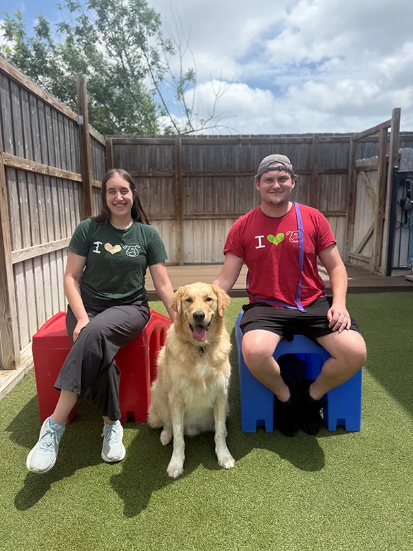 Two trainers sitting with a dog